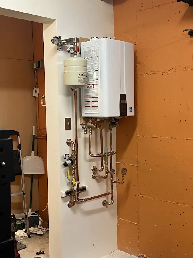 Plumbing technician inspecting water heater connections in Mitchellville
